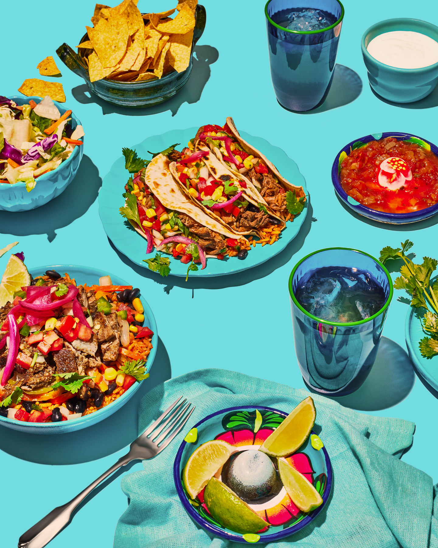 Colorful table spread of Mexican food including tacos, guacamole, and vibrant sides – bold and styled food photography