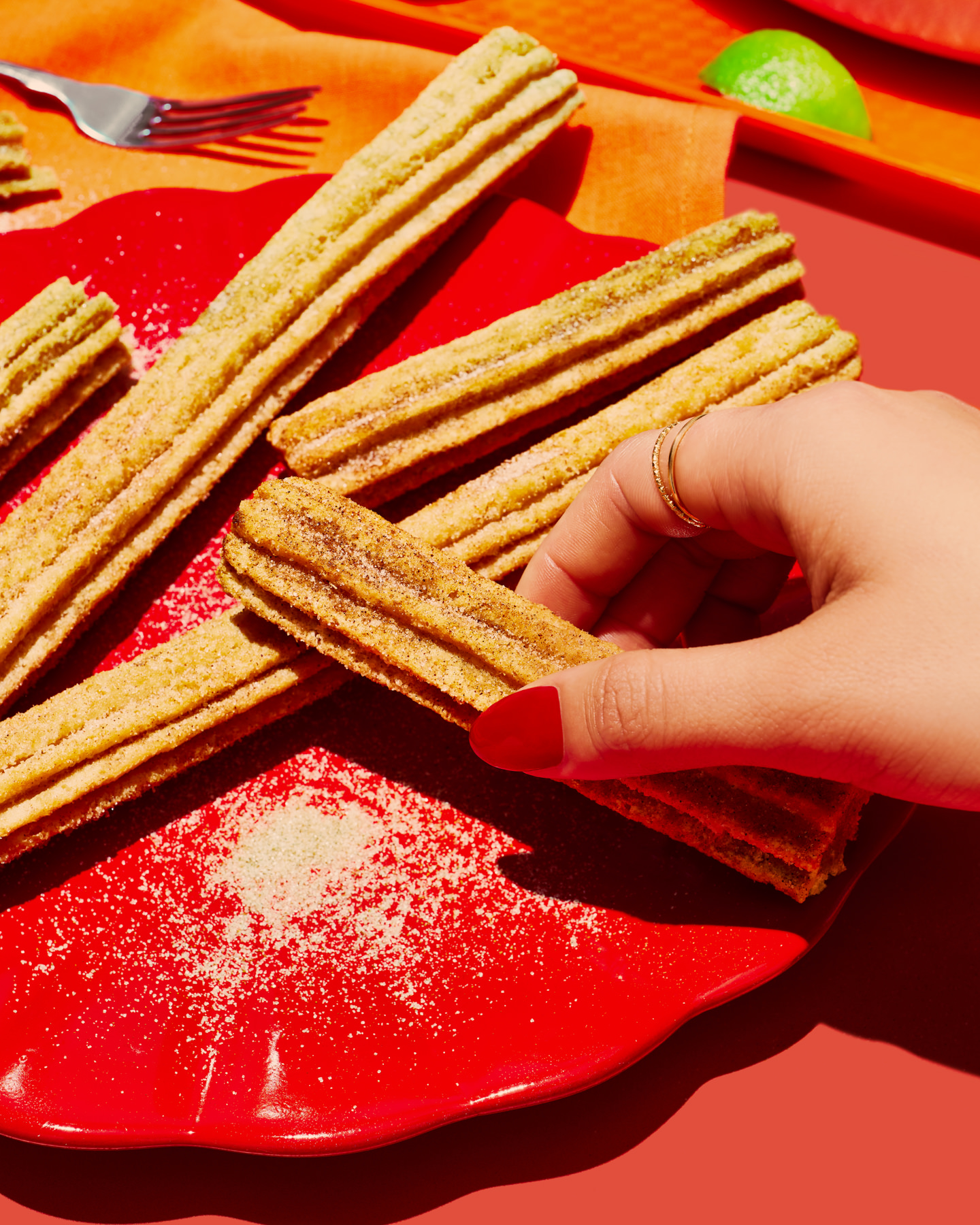 Hand picking up a churro on styled tabletop – commercial food photography