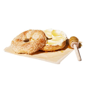 Sesame bagel with cream cheese and honey on parchment – menu food photographer Toronto