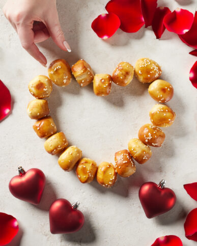Amidst a charming and romantic ambiance, a hand delicately reaches for pretzel bites, adding a touch of warmth and intimacy to a special occasion. This captivating image showcases our photography expertise in capturing memorable moments.